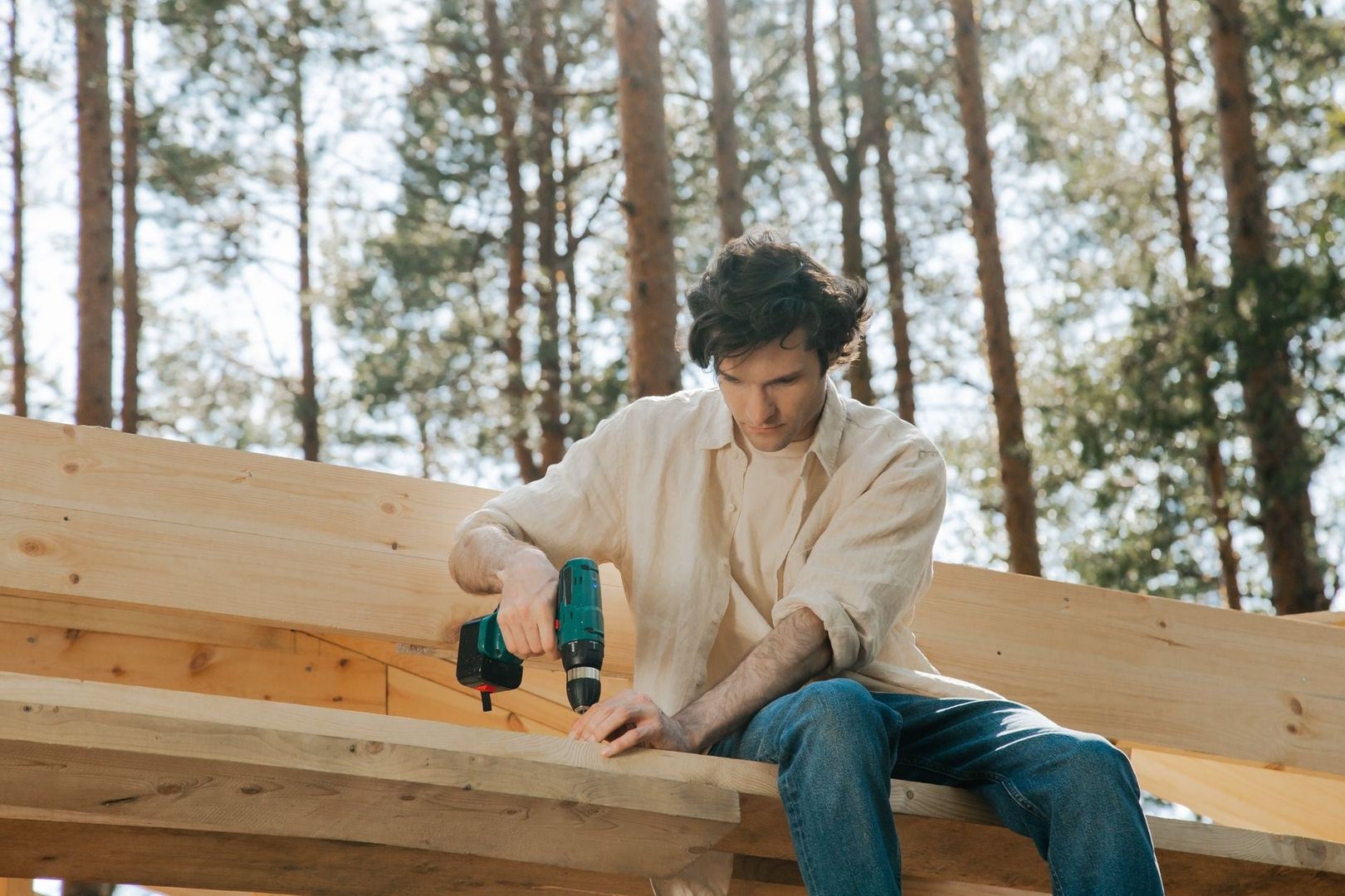 selected-02-person-using-battery-drill-indoors-optimized Person bruker en batteridrill på en trekonstruksjon i skogen